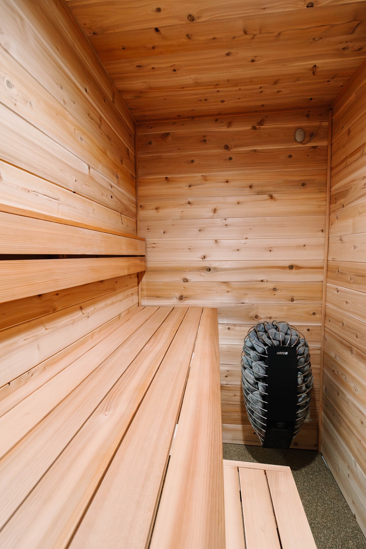 Stone-loaded heater beside cedar benches