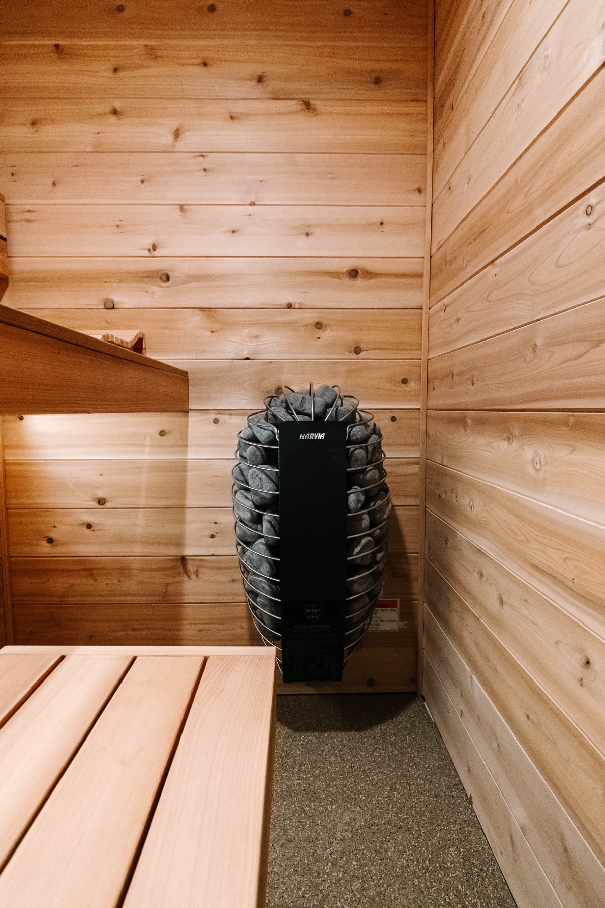 Stone-loaded Harvia heater against cedar walls