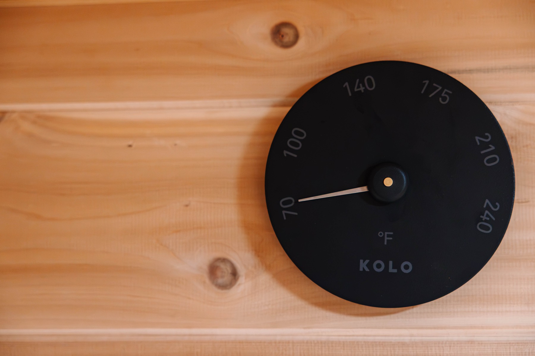 Black thermometer on a cedar wall